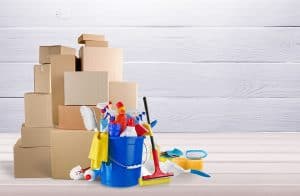 Bright empty room with moving boxes and cleaning supplies including a mop and bucket, representing move-out cleaning.